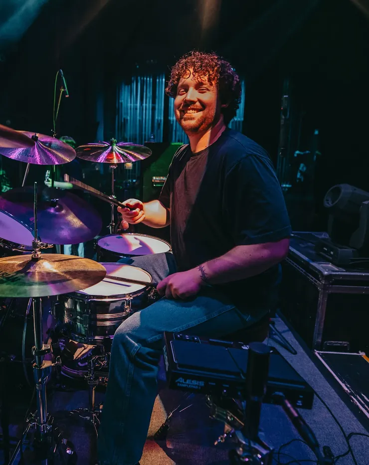 Andrew smiling behind his drum kit